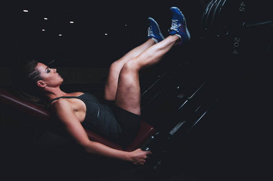 Woman intensively exercising on a leg press machine to revitalize workout routine